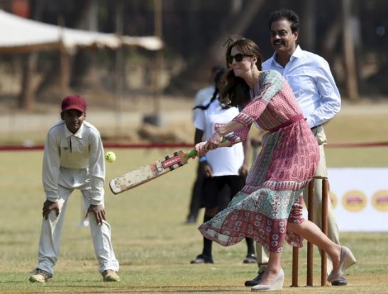 Catherine, Duchess of Cambridge, is watched by former Indian cricketer Dilip Vengsarkar as she and Britain's Prince William play a game of cricket with Indian children, who are beneficiaries of NGOs, at the Oval Maidan in Mumbai